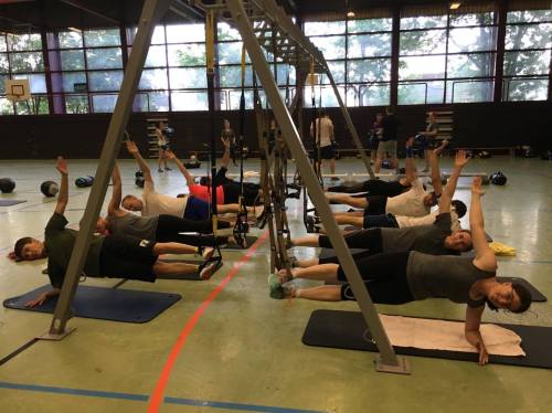 Teilnehmer bei Übung am TRX-Rahmen